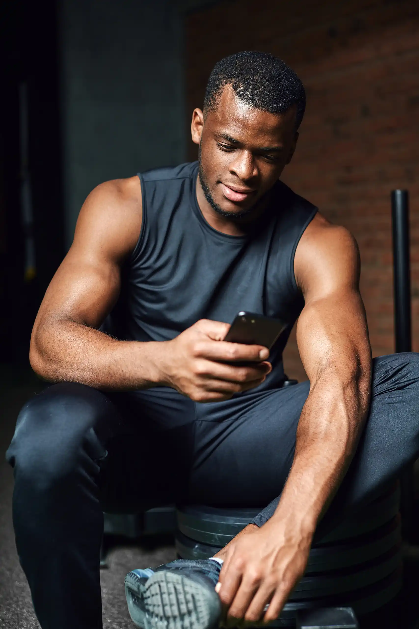 Sportlicher junger Mann nutzt die Fitnessstudio Member-App ClubConnector auf seinem Smartphone.